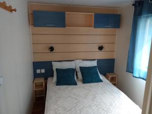 a bedroom with a bed with a headboard and two pillows at camping soleiluna in Herm