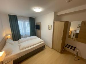 Hotel Hafner في شتوتغارت: غرفة نوم صغيرة بها سرير ونافذة