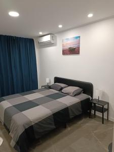 a bedroom with a large bed with blue curtains at Plaza Caparica Hostel in Costa da Caparica