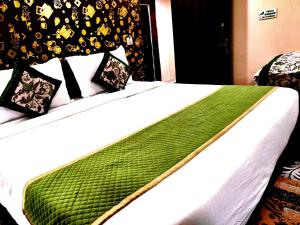 Una cama con una manta verde encima. en Tulsi Garden- Near Prem Mandir Vrindavan en Vrindāvan