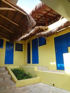 a building with blue doors and a grass roof at Pousada B & B in Águas de Lindoia