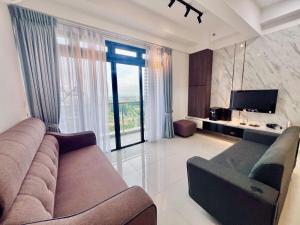 uma sala de estar com um sofá e uma televisão em Comfort Stay-4min to Legoland em Nusajaya