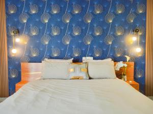 1 dormitorio con 1 cama con pared azul en Elegant Appartement BELAPPART, en Pointe-Noire