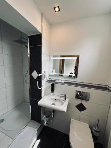 ein Badezimmer mit einem Waschbecken, einem WC und einem Spiegel in der Unterkunft Hotel Stadt Emmerich in Emmerich