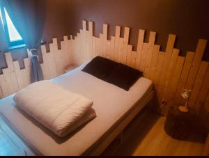 een bed in een kamer met een houten muur bij Noax gite Durbuy in Durbuy