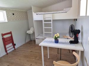 Zimmer mit einem Tisch und einem Etagenbett in der Unterkunft Korskullens Stugor in Söderköping