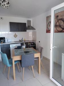 a kitchen with a table and chairs in a room at studio rdc avec terrasse et parking privé in Agde