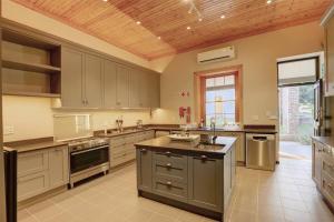 a large kitchen with stainless steel appliances and a wooden ceiling at Almond Valley Manor House in Buffelskloof