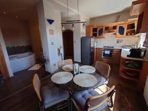 a kitchen and dining room with a table and chairs at Wellness Lakás in Nyíregyháza