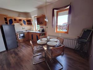 eine Küche mit einem Tisch und Stühlen im Zimmer in der Unterkunft Wellness Lakás in Nyíregyháza
