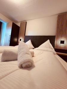 Una cama blanca con un animal de peluche. en Hotel Stadt Emmerich, en Emmerich