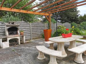 a picnic table with a fireplace in a backyard at Gite du Persil - Meublé de Tourisme 3 étoiles in Le Mesnil-Simon