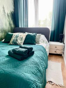 a bed with pillows on it in a room with a window at Chillout Airport Apartment KL33 - Free parking in Warsaw