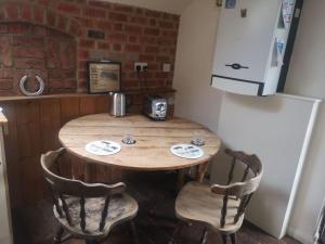 uma cozinha com uma mesa de madeira com cadeiras e um frigorífico em Owl's Barn Quiet & private Twin bed 
