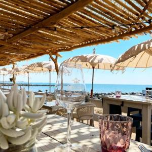 un bicchiere di vino seduto sopra un tavolo vicino alla spiaggia di Charmant appartement - Residence avec piscine a Montpellier
