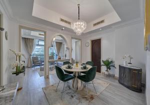 ein Wohnzimmer mit einem Tisch und grünen Stühlen in der Unterkunft Burj khalifa partial view Peak living luxury 2BR Souk AL-Bahar Beside Dubai mall-GOLDEN HOMES in Dubai