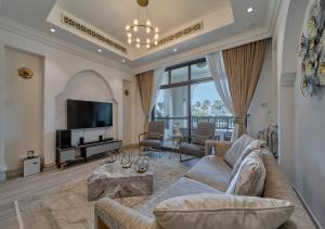 ein Wohnzimmer mit einem Sofa und einem TV in der Unterkunft Burj khalifa partial view Peak living luxury 2BR Souk AL-Bahar Beside Dubai mall-GOLDEN HOMES in Dubai