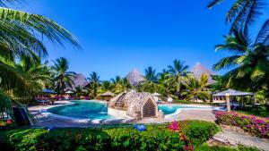 una piscina in un resort con palme e fiori di Tembo Court Apartments(Ocean Beach) a Malindi