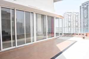 an empty balcony of a building with glass windows at Niva Stays Marvel 1 in Pune