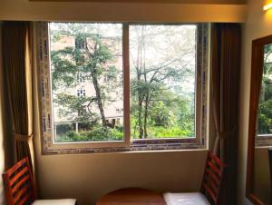 a window in a room with two chairs looking out at The Bassu's Gangtok in Gangtok