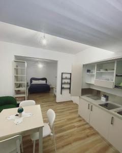 B&B Villa Mariotta في أمانتيا: مطبخ وغرفة معيشة مع طاولة وكراسي