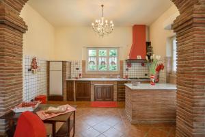 una cocina con una pared de ladrillo y una lámpara de araña en POMODORO di Home Hill, en Capannori