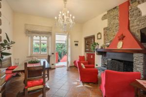 sala de estar con chimenea y sillas rojas en POMODORO di Home Hill, en Capannori