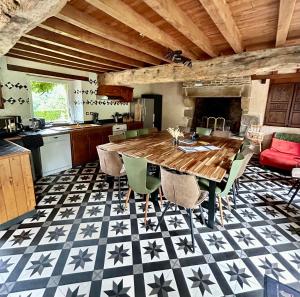 a kitchen with a large wooden table and chairs at Hambye'ance Nature 28pers spa finlandais billard in Hambye