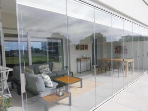 uma sala de estar com paredes de vidro e um sofá em SOTOGRANDE Hoyo 10 em Sotogrande