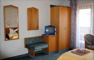 a hotel room with a television and a bed at Gasthof Stern in Burgsinn