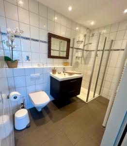 ein Bad mit einem WC, einem Waschbecken und einer Dusche in der Unterkunft Coast House Moana in Bremerhaven