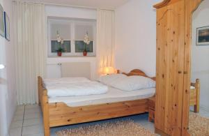1 cama con marco de madera en una habitación en NTBM36002-FeWo-Kiekut, en Neue Tiefe Fehmarn