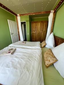 2 Betten in einem Zimmer mit grünen Wänden in der Unterkunft Coast House Moana in Bremerhaven