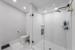 ein weißes Badezimmer mit Dusche und Toilette in der Unterkunft Lux Family Pool Spa, 2 Private Pickleball Courts, Ping Pong Table, Mini Golf, Close To Beach & Dining Home Sleeps 8 in Naples