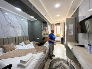 a man and a woman standing next to a bed at New Minor Hotel in Khiva
