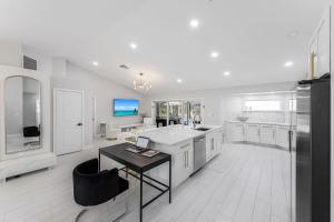 eine große Küche mit weißen Schränken und einem schwarzen Tisch in der Unterkunft Lux Family Pool Spa, 2 Private Pickleball Courts, Ping Pong Table, Mini Golf, Close To Beach & Dining Home Sleeps 8 in Naples + 38 Fotos