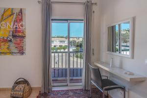 een kamer met een bureau en een raam met een balkon bij Luz casas-St James 215, 3 bedrooms,wi fi, air con,shared pool in Luz