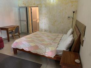 a bedroom with a bed and a table and a desk at Paradialaw in Rufisque