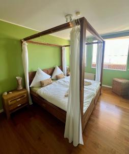 ein Schlafzimmer mit einem Himmelbett mit Baldachin in der Unterkunft Coast House Moana in Bremerhaven