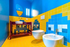 La salle de bains colorée est pourvue de toilettes et d'un lavabo. dans l'établissement The Match Hotel, à Cervia