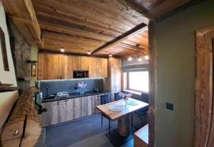 a kitchen with wooden walls and a table in a room at Domki pod sosnami in Kacwin