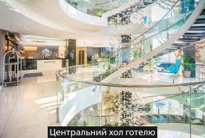 eine Wendeltreppe in einem Einkaufszentrum mit Glas in der Unterkunft NEMO Hotel Resort & SPA in Odessa