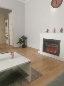 a living room with a fireplace and a table at Sidus in Satu Mare