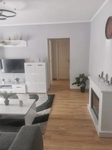 a white living room with a couch and a table at Sidus in Satu Mare