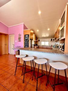 eine Küche mit einer Bar mit vier Stühlen in der Unterkunft Casas Jeronimos in Lourinhã