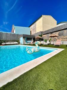 - une piscine avec une sirène en plastique dans l'herbe dans l'établissement Casas Jeronimos, à Lourinhã