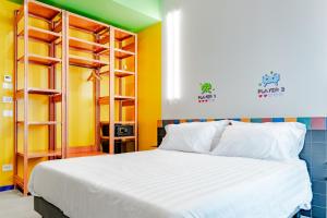- une chambre avec un lit blanc et des étagères dans l'établissement The Match Hotel, à Cervia
