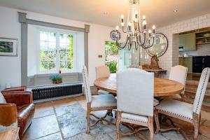 a dining room with a table and chairs and a chandelier at Magnificent Clarence cottage! in Swanage