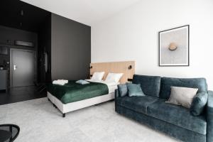 CityCenter Sauna & Fitness Apartments Podgórna by Renters Prestige في بوزنان: غرفة معيشة مع سرير وأريكة