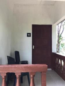 una mesa de madera en una habitación con sillas y una puerta en D view hill hotel, en Kuala Tahan